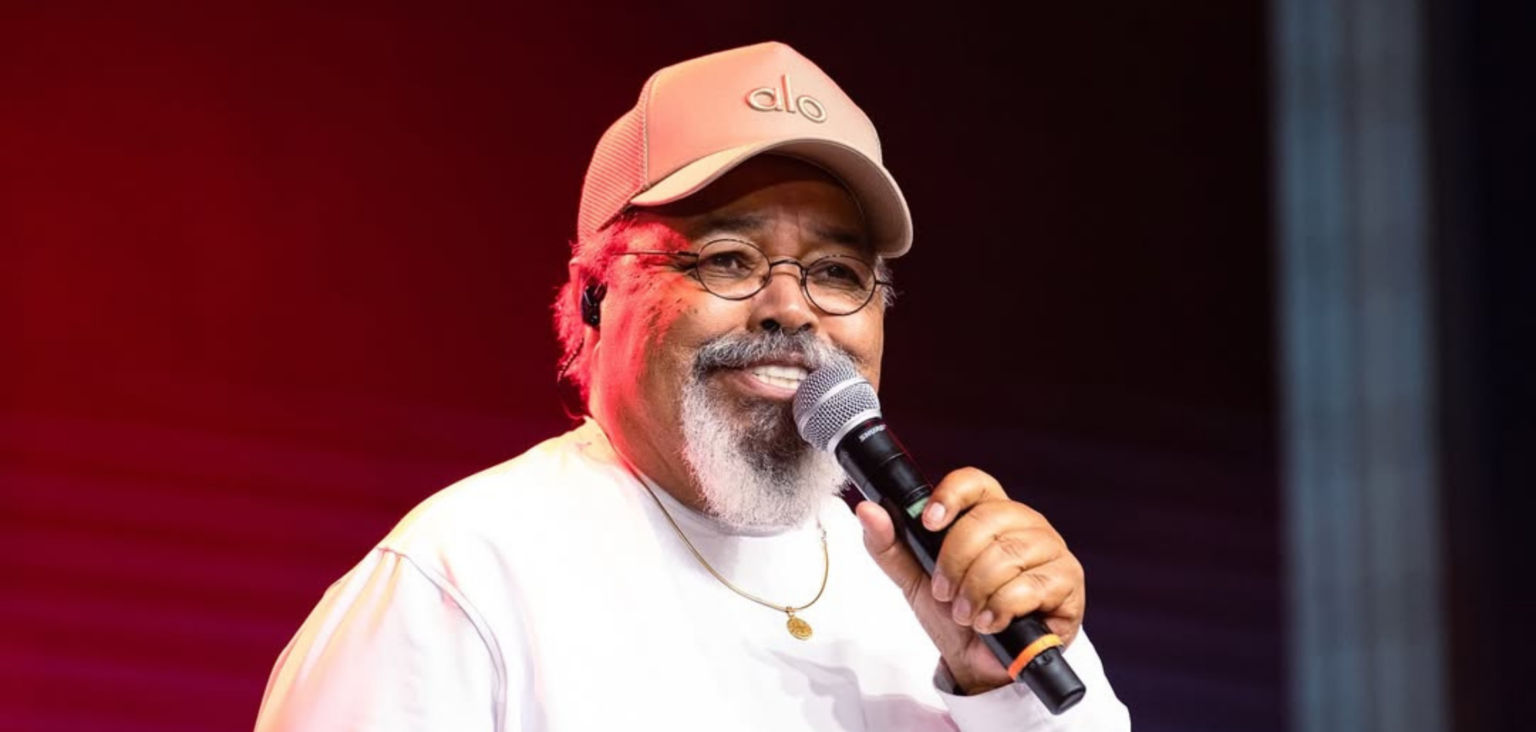 Jorge Aragão em show, com microfone em mãos.